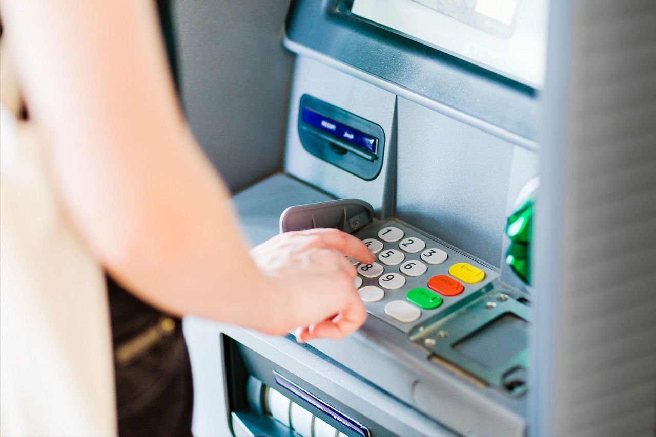 Frau hebt am Geldautomat Bargeld ab