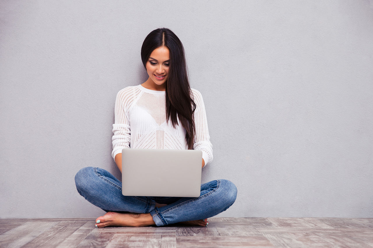 Frau im Schneidersitz mit Laptop