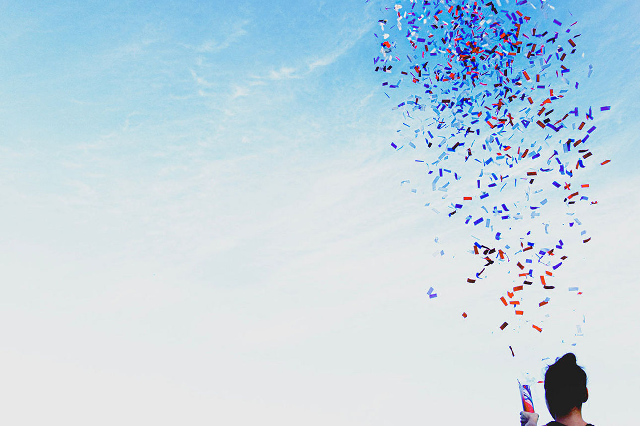 Frau vor Himmel mit Konfetti