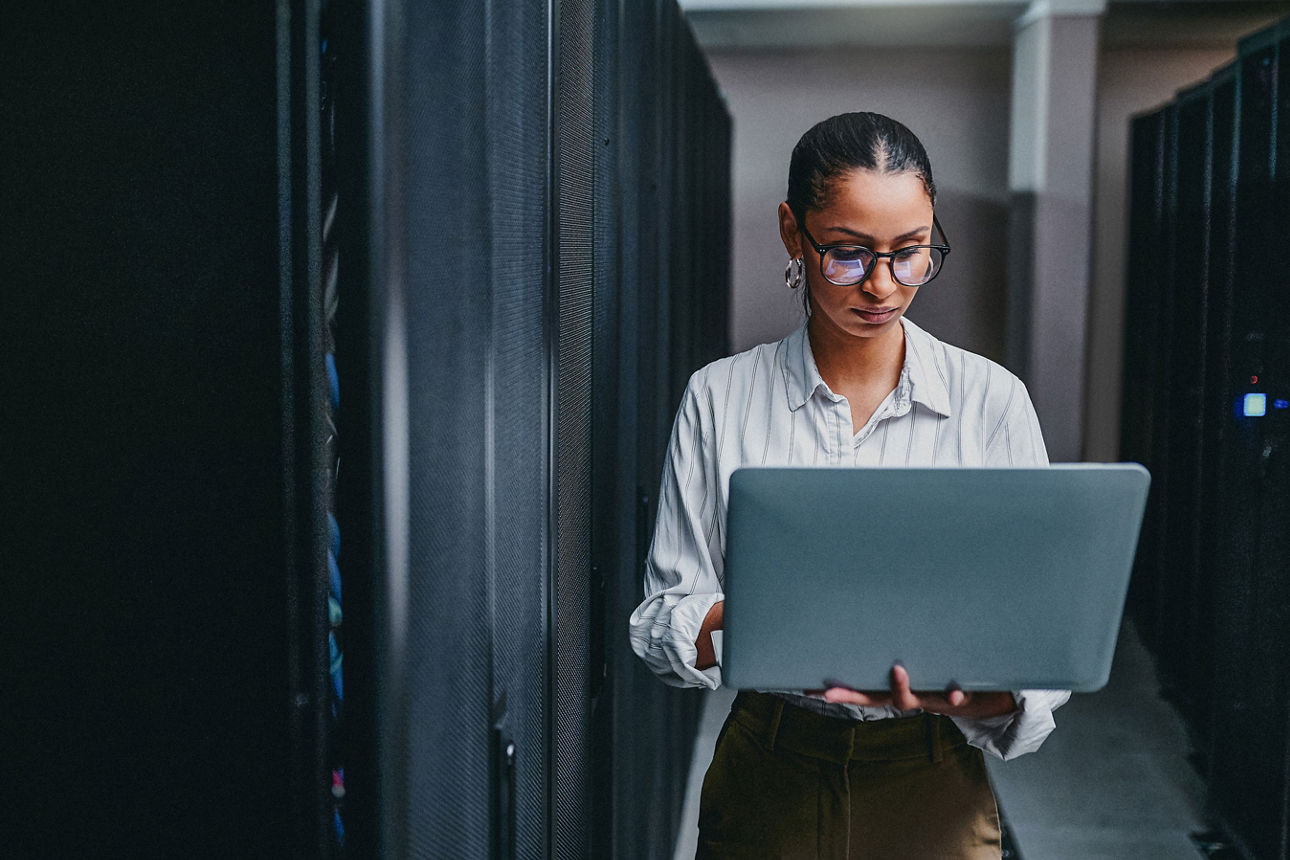 Ein Mann sitzt am Schreibtisch mit Laptop und schaut in den Monitor