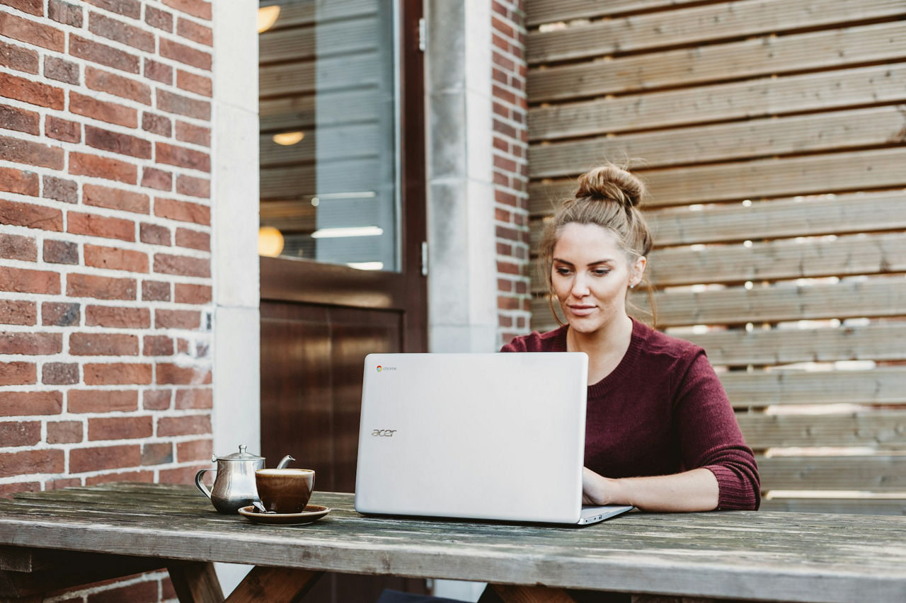 Frau sitzt vorm Laptop und arbeitet