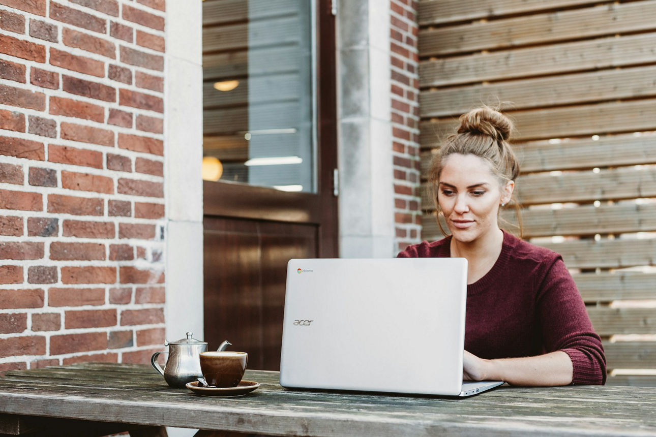 Frau sitzt vorm Laptop und arbeitet