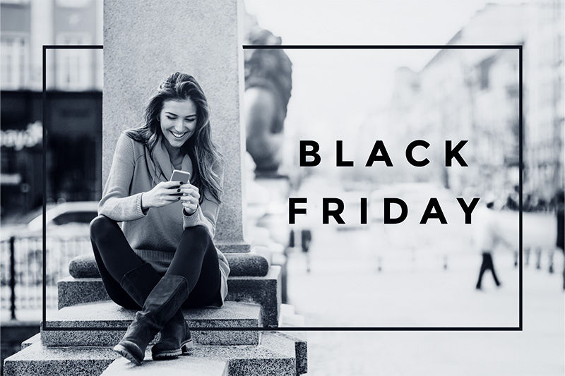 Frau sitzt auf einer Treppe und schaut in ihr Smartphone