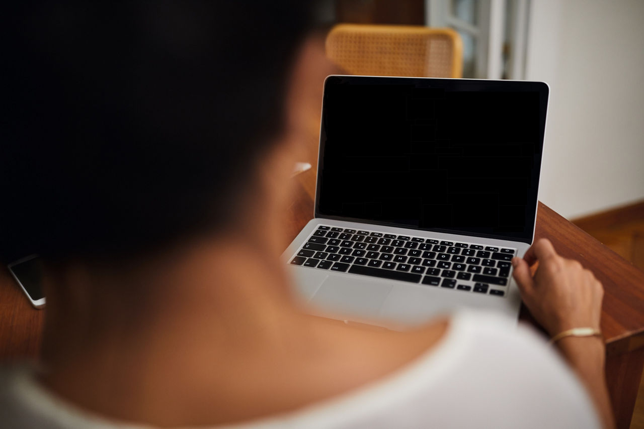 Frau vor schwarzem Laptop