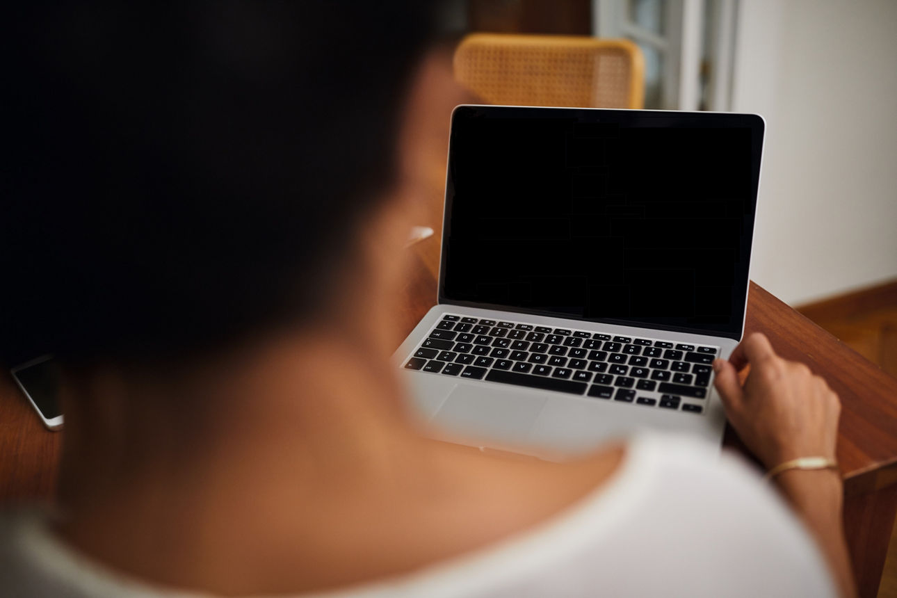 Frau vor schwarzem Laptop