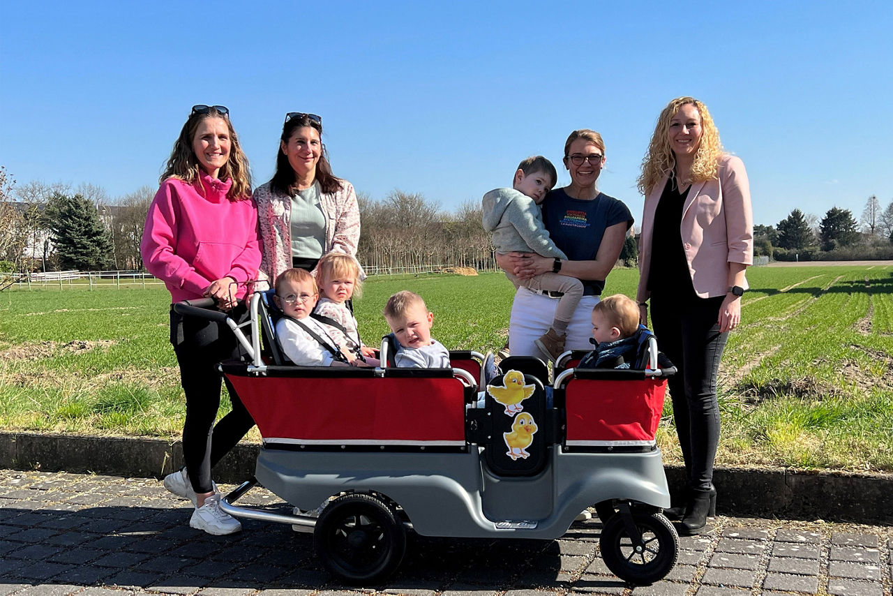 Frauen-und-Kinder-stehen-zusammen-um-einen-kleinen-Mini-Bus