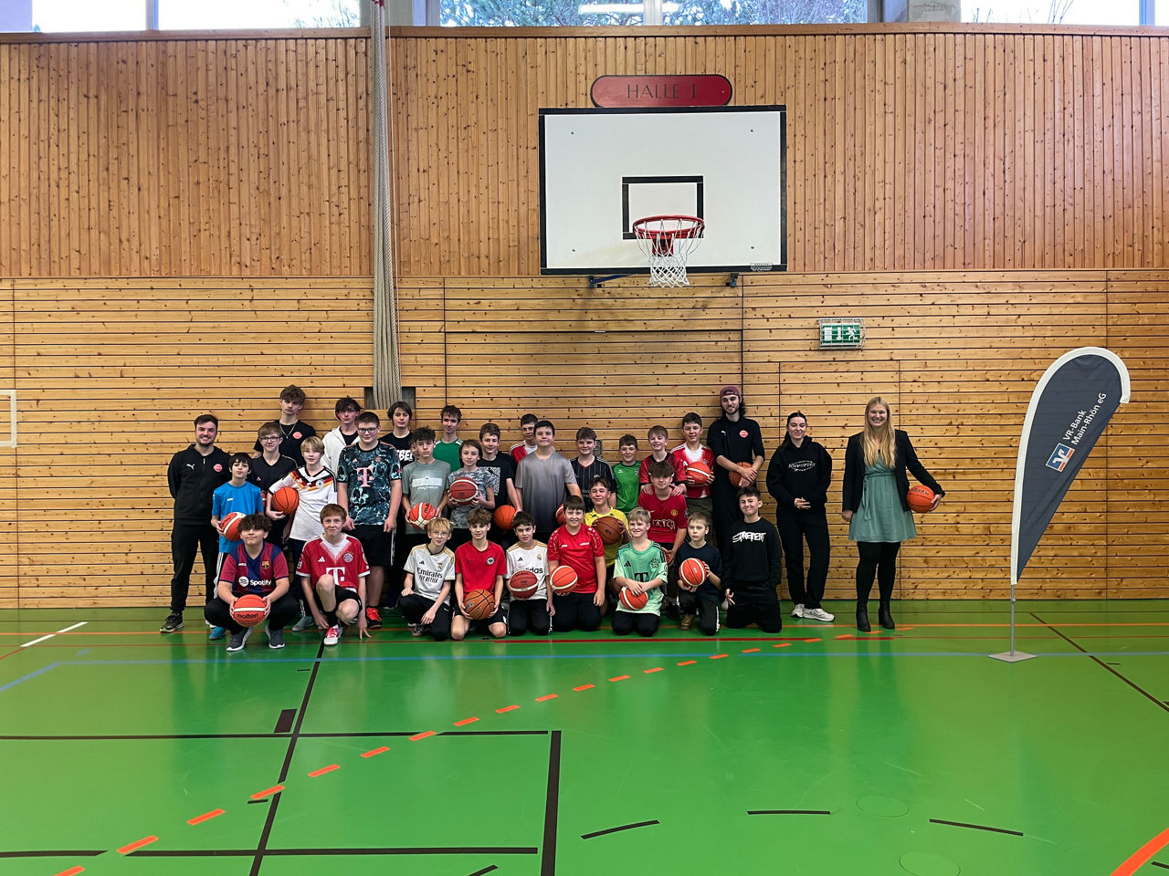 Zu sehen ist das das Jugendtrainerteam des Freak City Bamberg e.V. mit Schülerinnen und Schülern der Ignaz-Reder-Realschule. Das Foto wurde in einer Turnhalle gemacht.