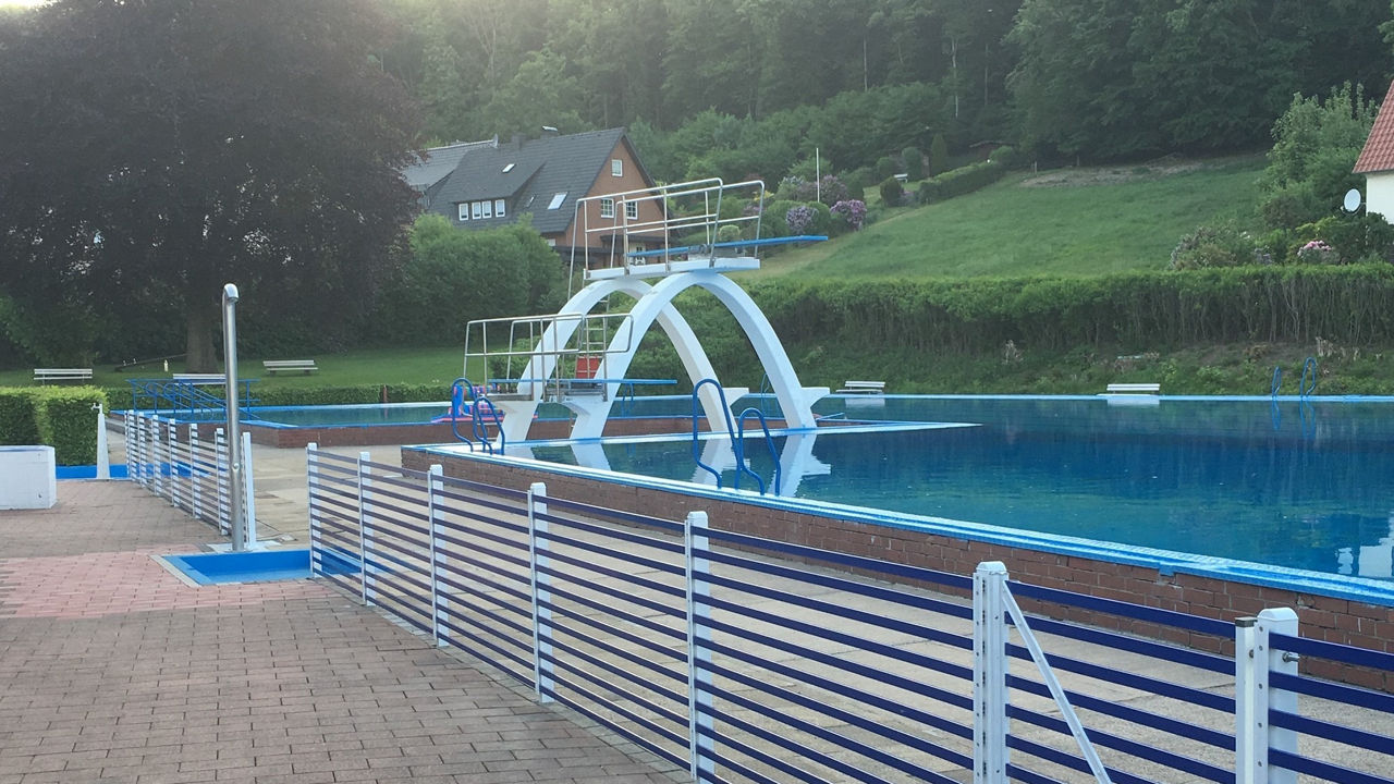 Schwimmbecken mit Sprungtürmen, Dusche und Liegewiese