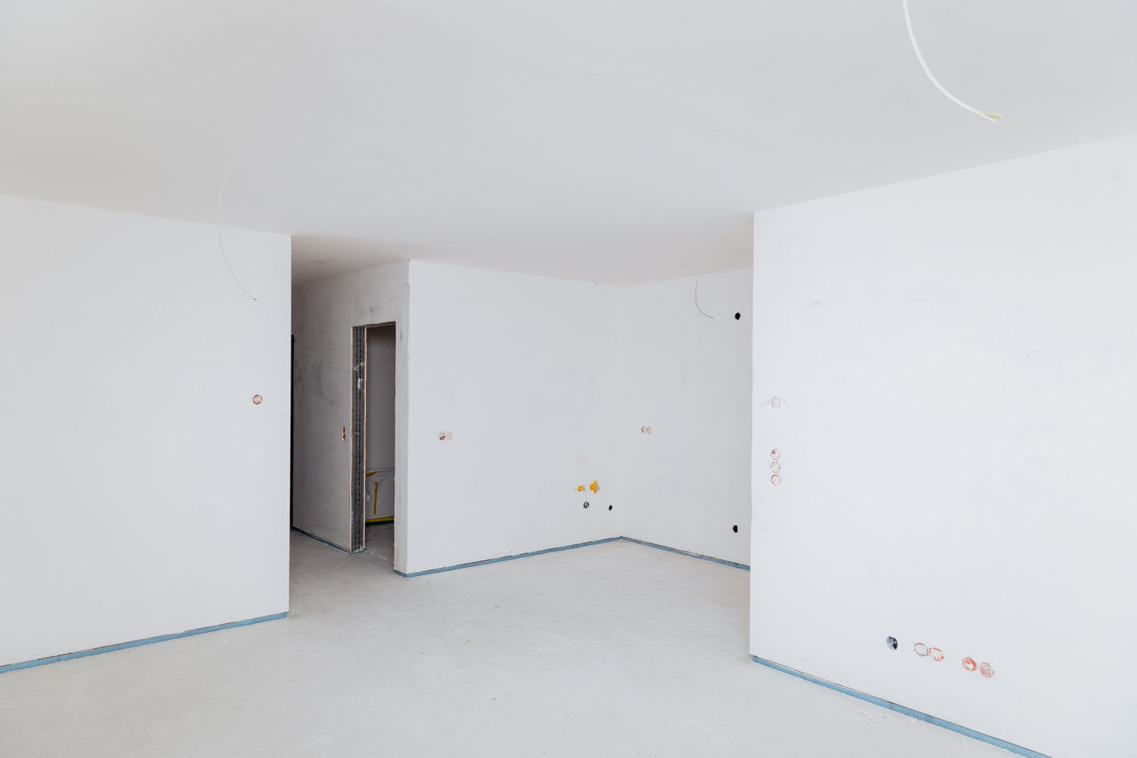 Unfertiger Innenraum eines Neubaus eines Wohnbauprojekts von „Friedrich Bau“ mit sichtbaren Installationspunkten und vorbereiteten Wänden. Die Aufnahme zeigt einen typischen Ausbauzustand im modernen Wohnungsbau und dokumentiert den aktuellen Stand der Innenausbauarbeiten