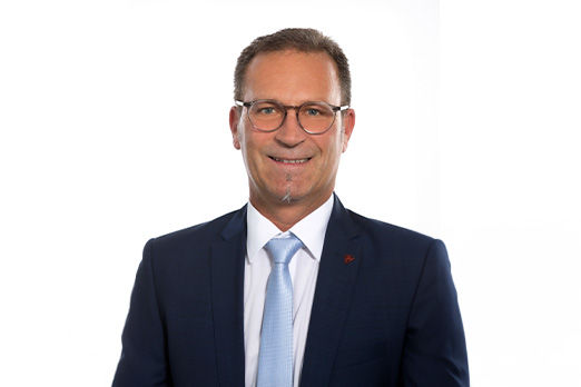 Freundlich lächelnder Mann im Anzug, unser Vorstand Ludwig Frischmann.