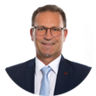 Ein freundlich lächelnder Mann im Anzug