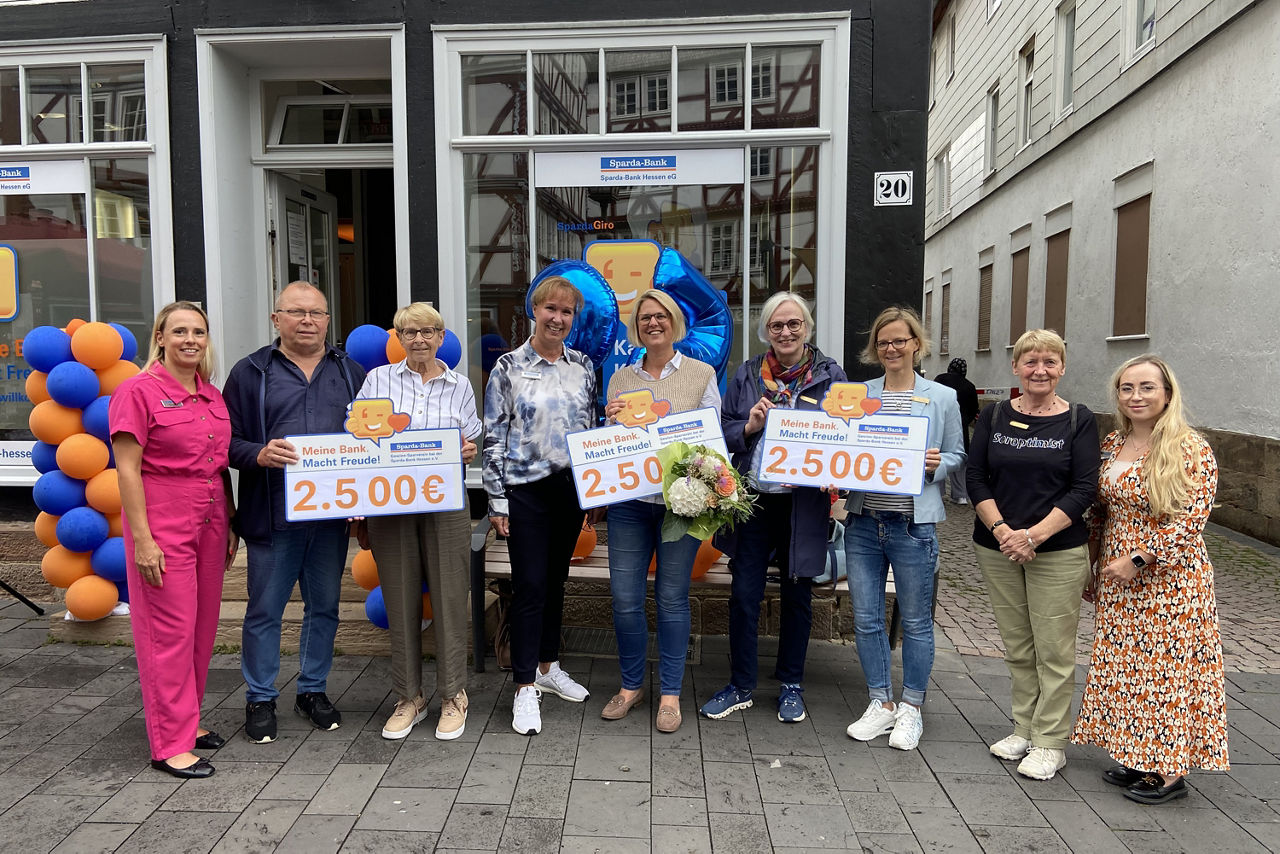 Gruppenbild der Spendenempfänger:innen mit Filialmitarbeitenden