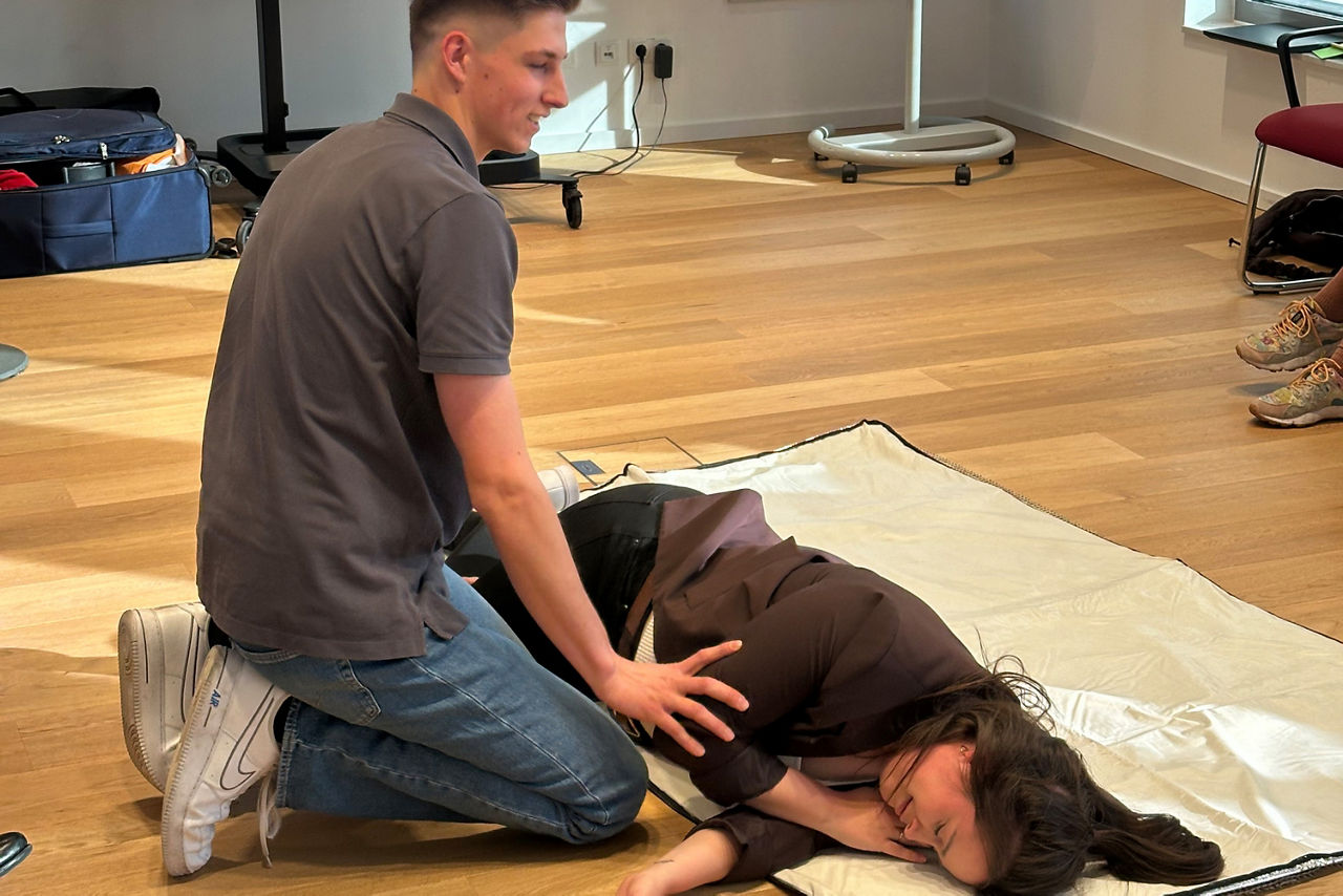 Ersthelferübung: Ersthelfer legt den Patienten in die stabile Seitenlage