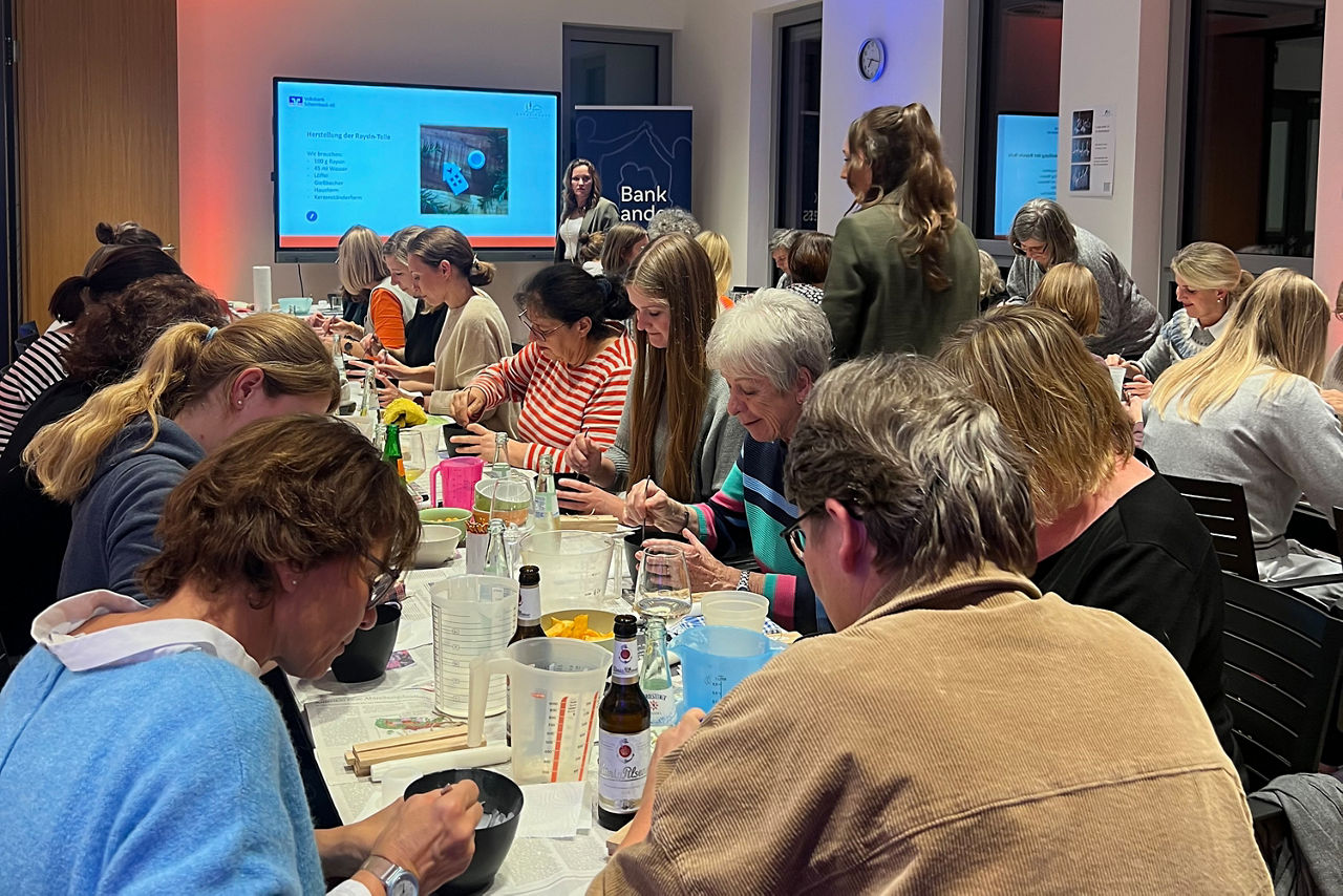 Frauen sitzen am Tisch und arbeiten mit Raysin.