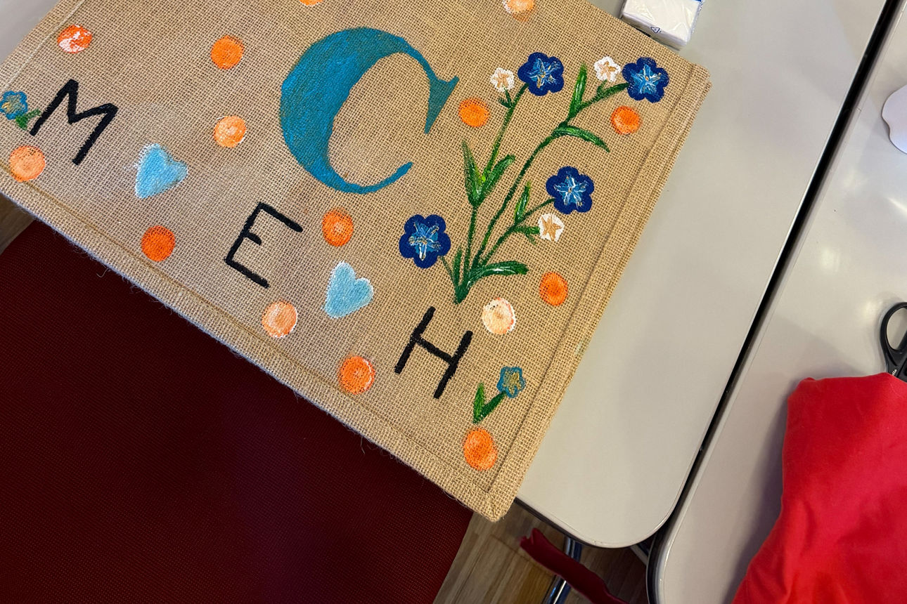 Frauen bemalen Taschen an einem Tisch