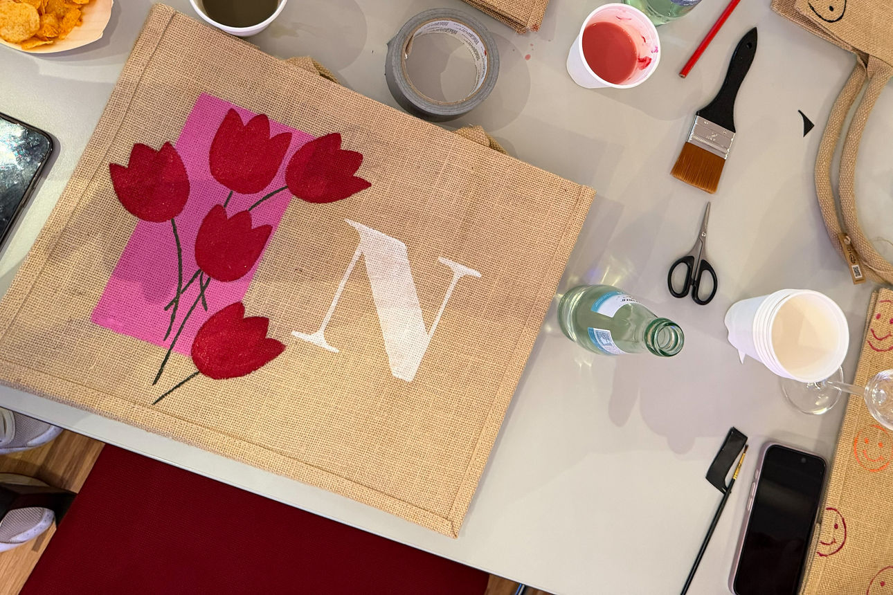 Frauen bemalen Taschen an einem Tisch