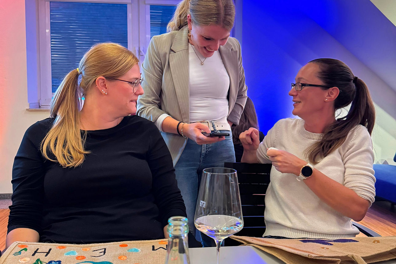 Frauen bemalen Taschen an einem Tisch