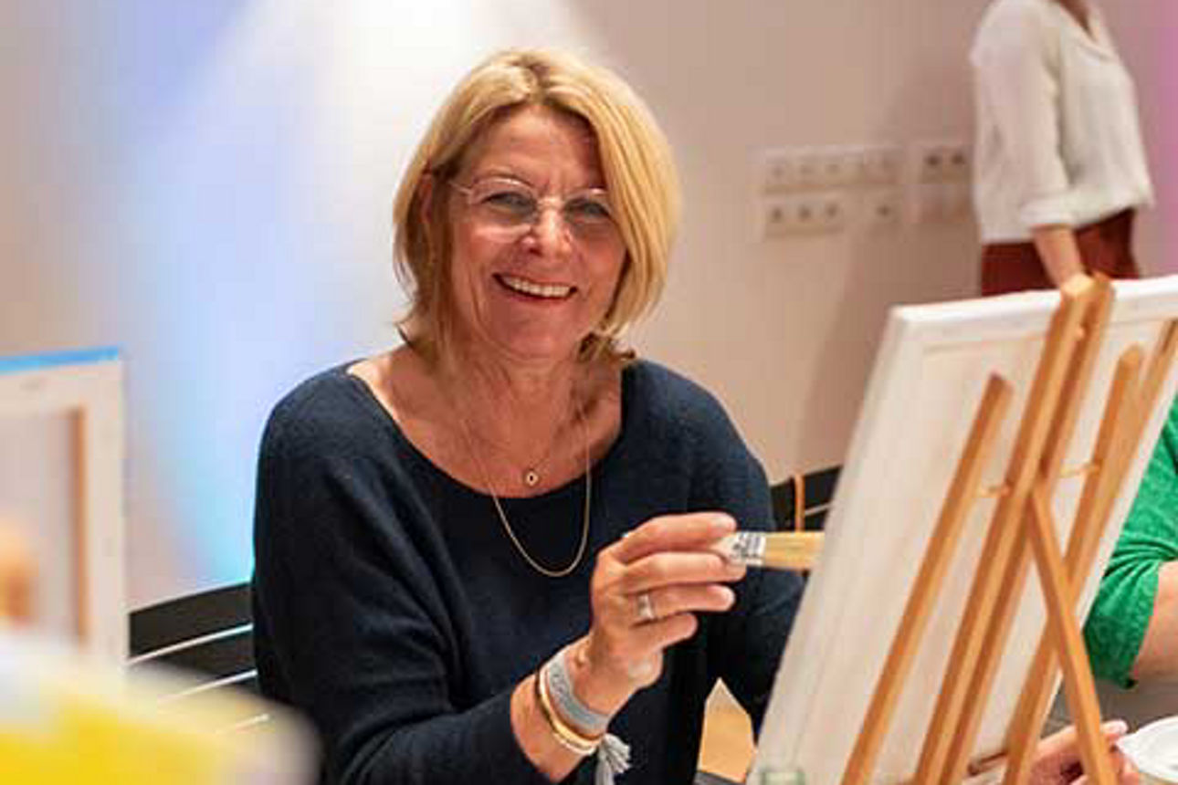 Kundin malt auf ihrer Staffelei