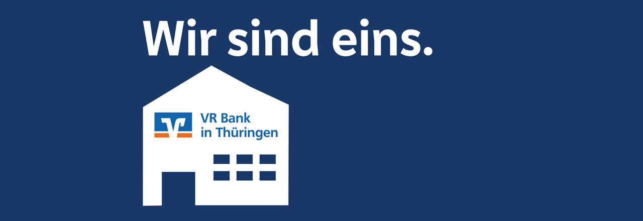 Weißes Haus mit Logo der VR Bank in Thüringen auf dunkel blauen Hintergrund.