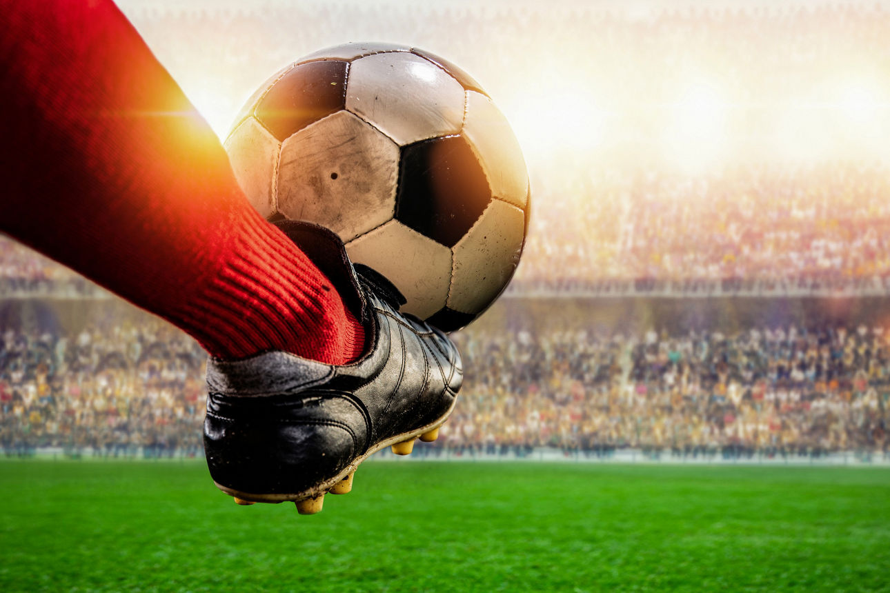 Ein Fuß kickt einen Fußball im Station