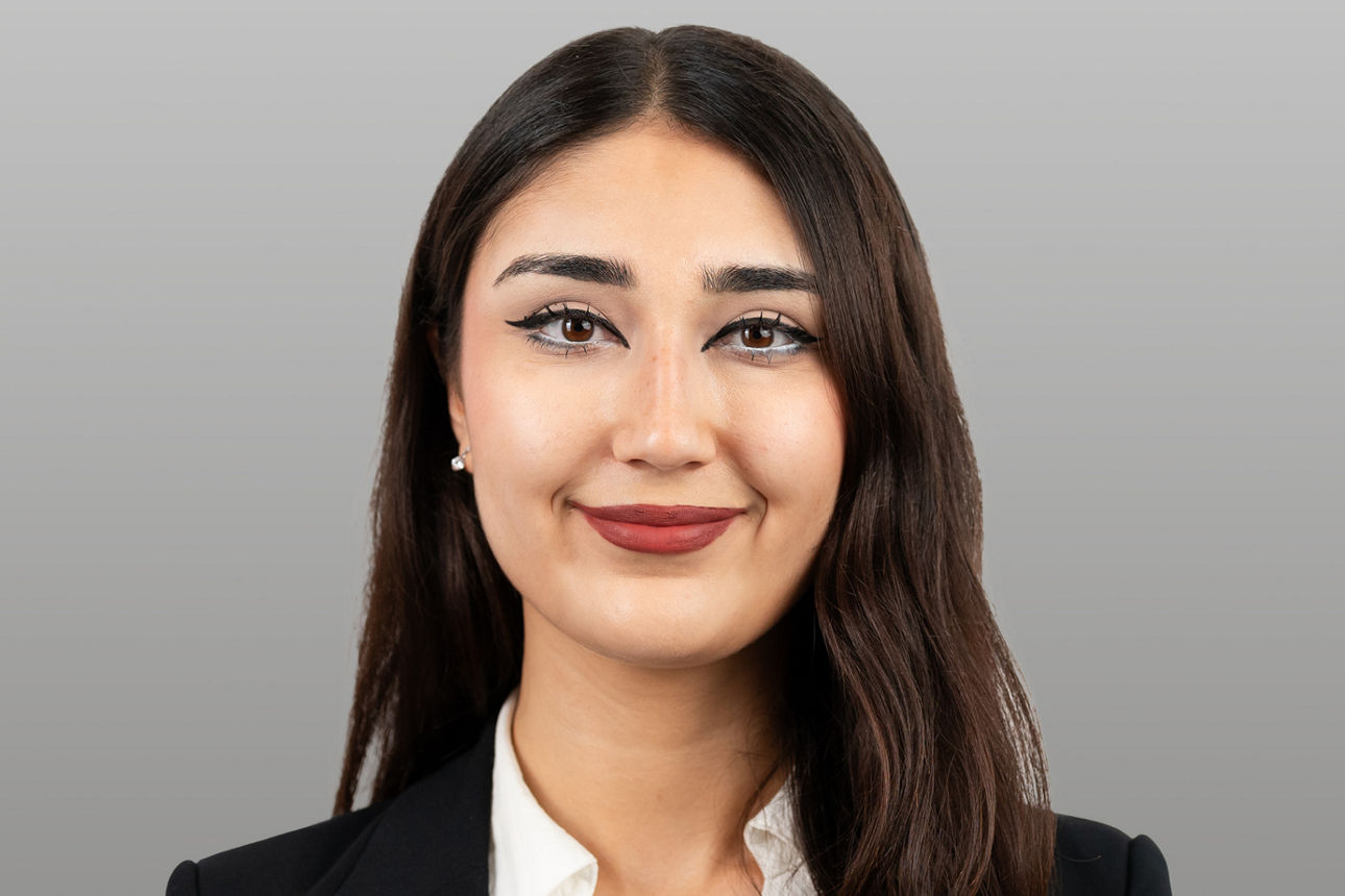 Servicemitarbeiterin Aslihan Görgülü vor grauen Hintergrund