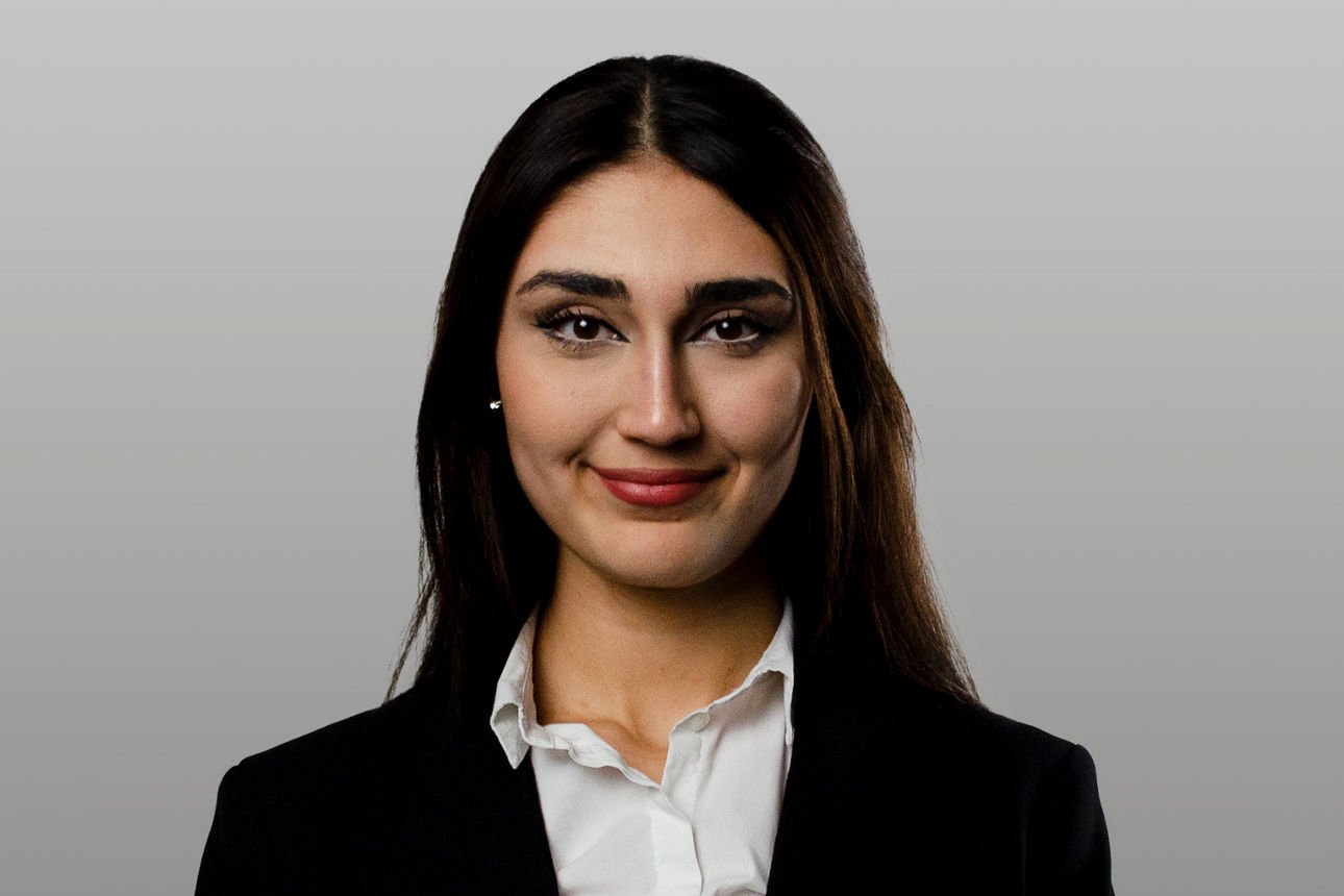 Servicemitarbeiterin Aslihan Görgülü vor grauen Hintergrund