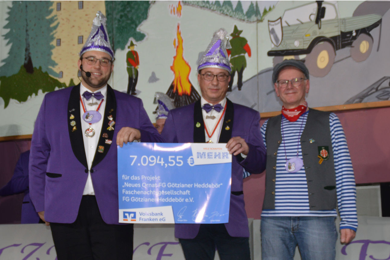 Drei Personen stehem miteinander und halten ein Plakat