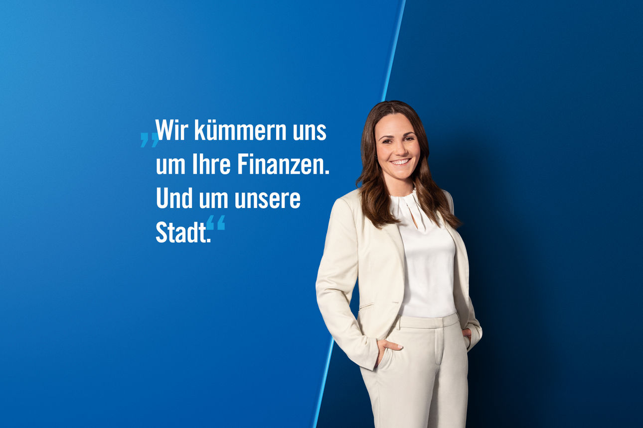 Gladbacher Bank Privatkundenberaterin im weißen Hosenanzug vor einem blauen Hintergrund