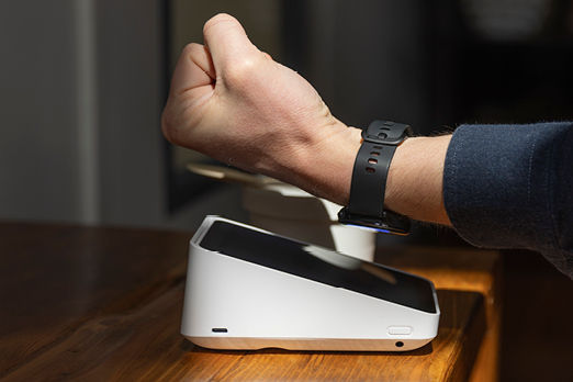 Hand die mit der Garmin Uhr am Kartenleser bezahlt
