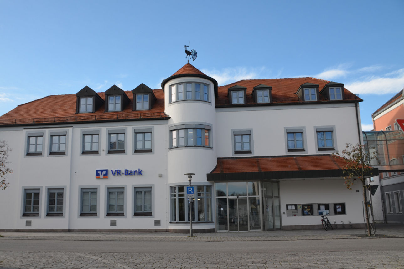 Ein älteres weißes Gebäude an einer Hauptstraße.
