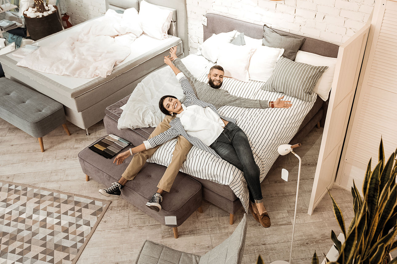 Mann und Frau auf dem Bett liegend Arme ausgestreckt