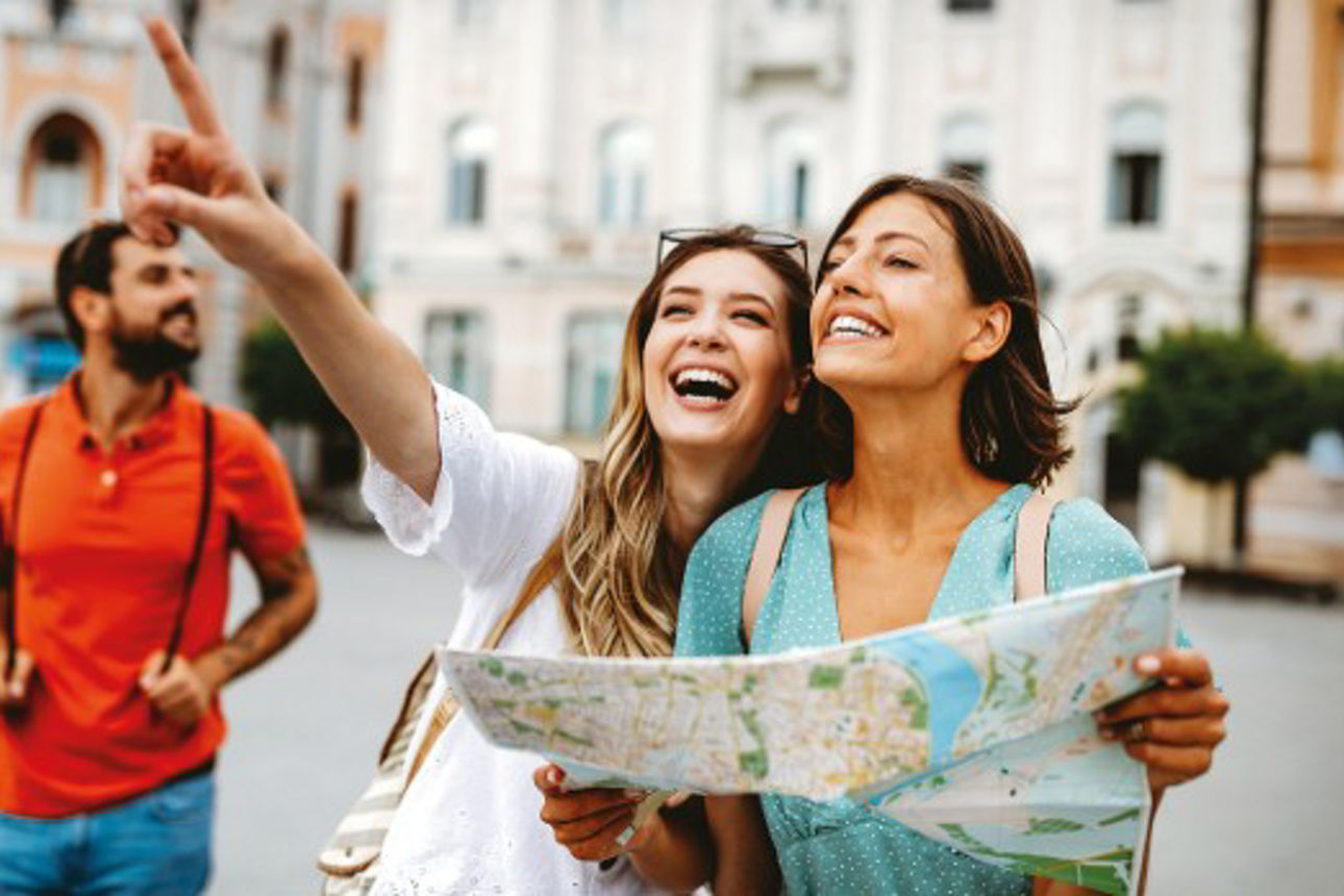 Zwei Frauen lachen und halten eine Karte in der Hand