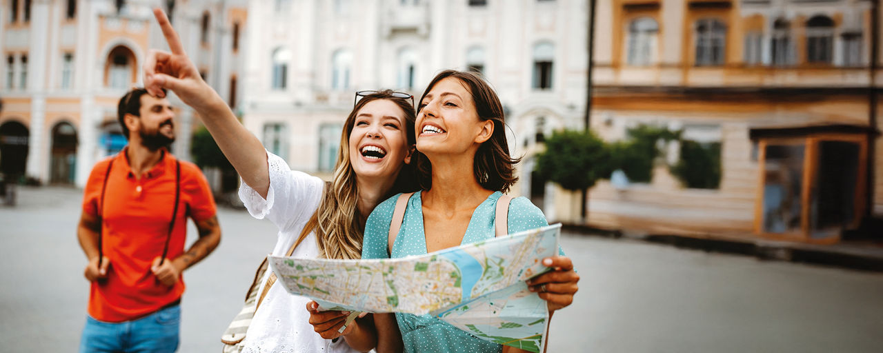 Zwei Frauen mit Straßenkarte lachend