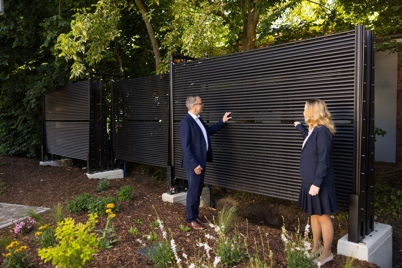 Zwei Personen zeigen die Besonderheiten der Bauweise der Geschäftsstelle Hille.