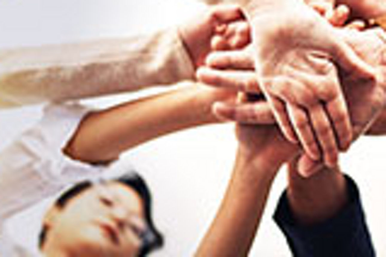 Mehrere Menschen legen die Hände übereinander