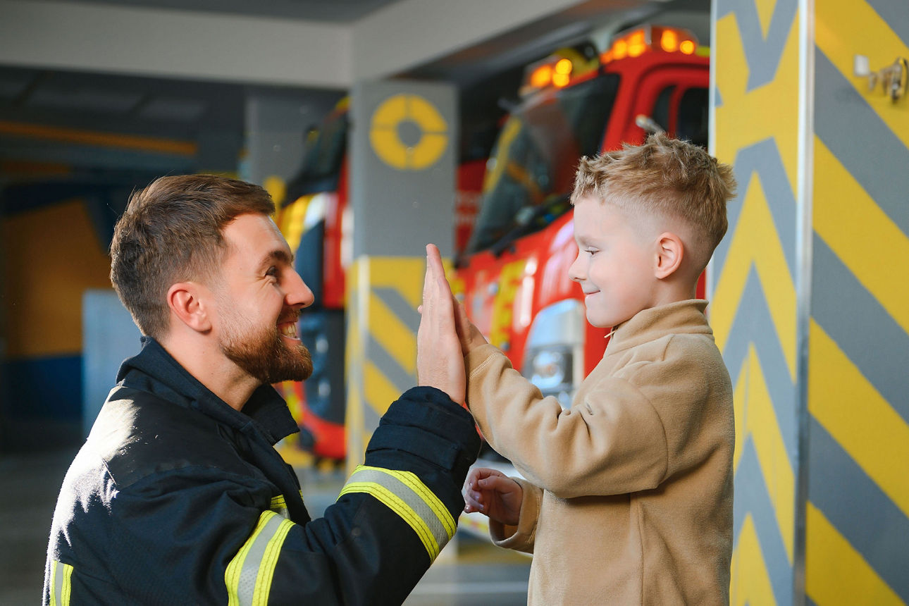 Feuerwehrmann gibt einem Jungen High-Five