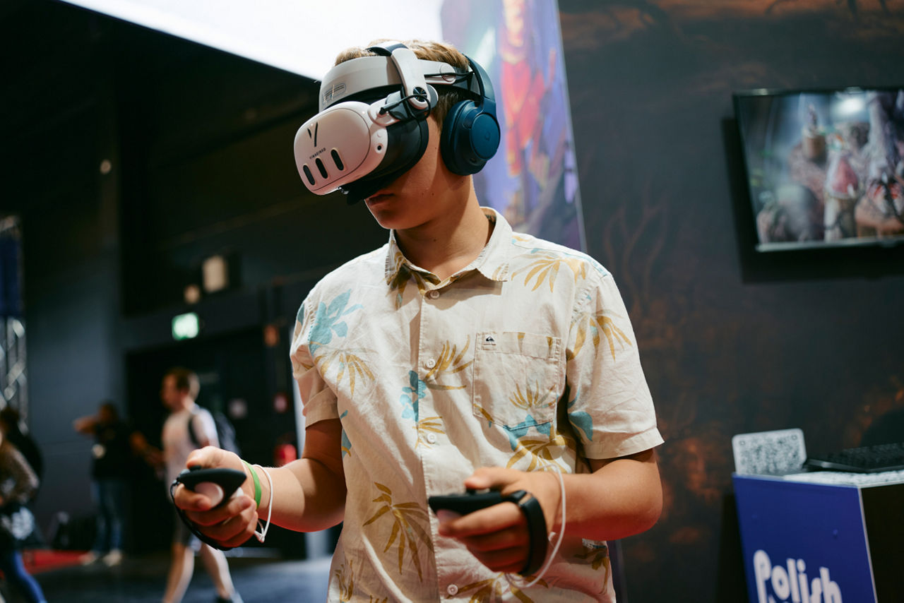 Junger Mensch mit VR-Brille und Handcontrollern