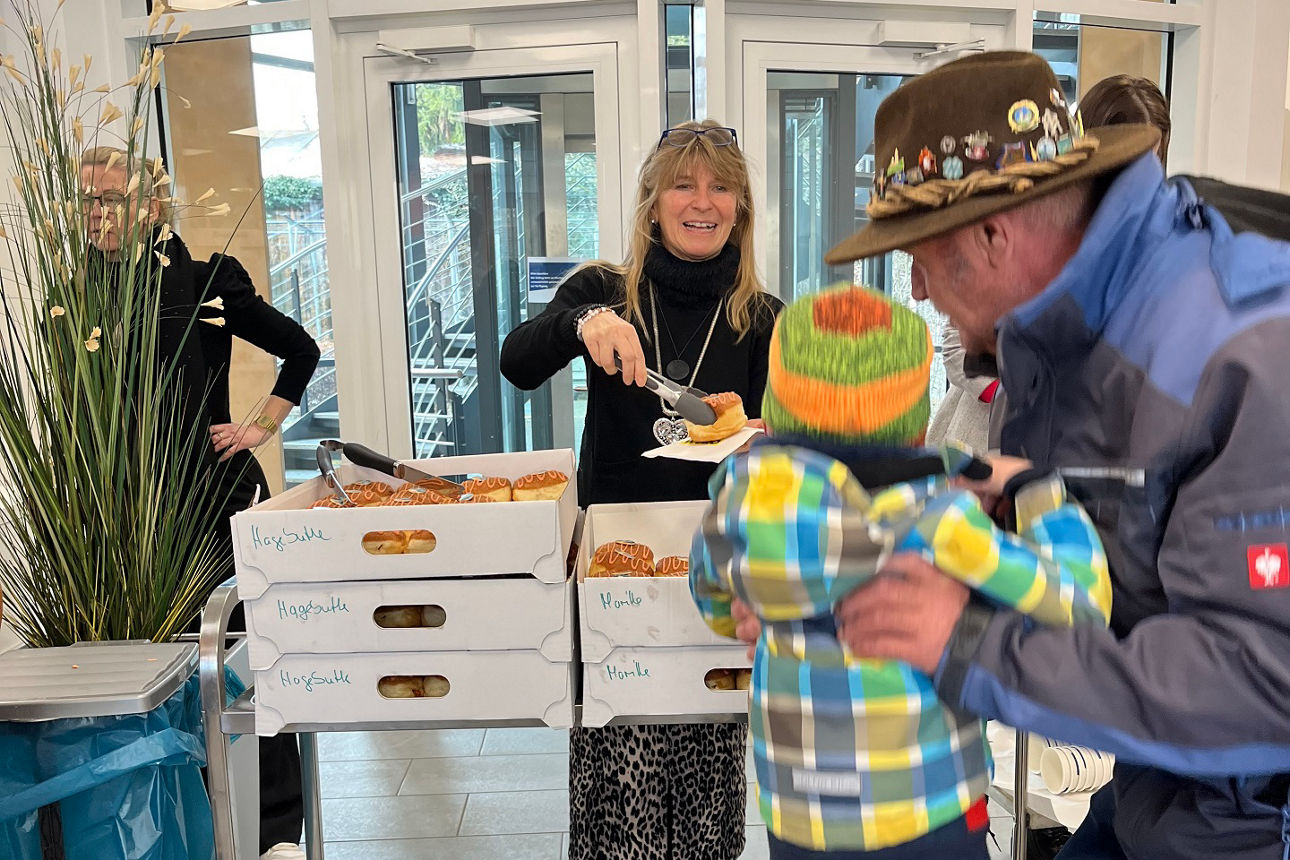 Kind wir hochgehoben, damit es einen Krapfen bekommt.