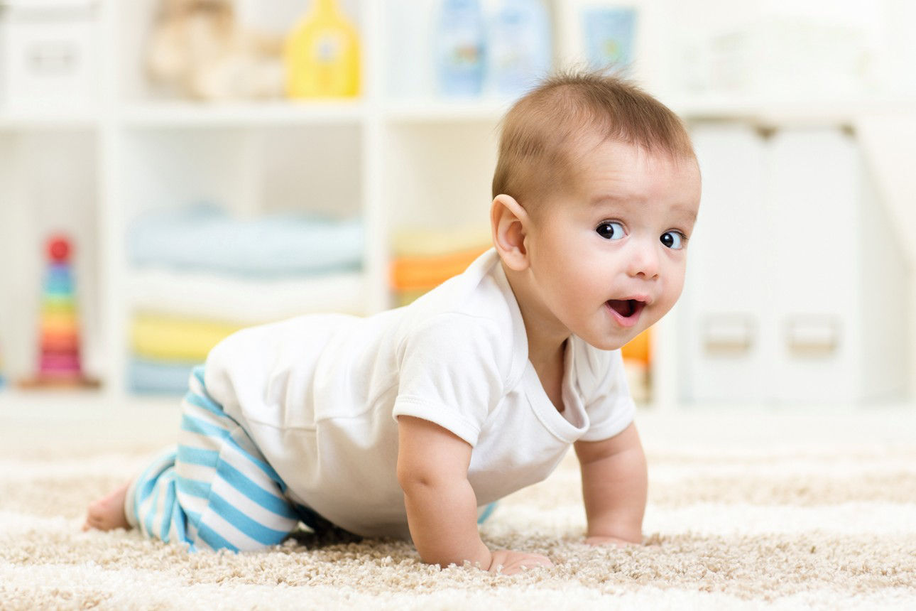 Baby krabbelt über Teppich