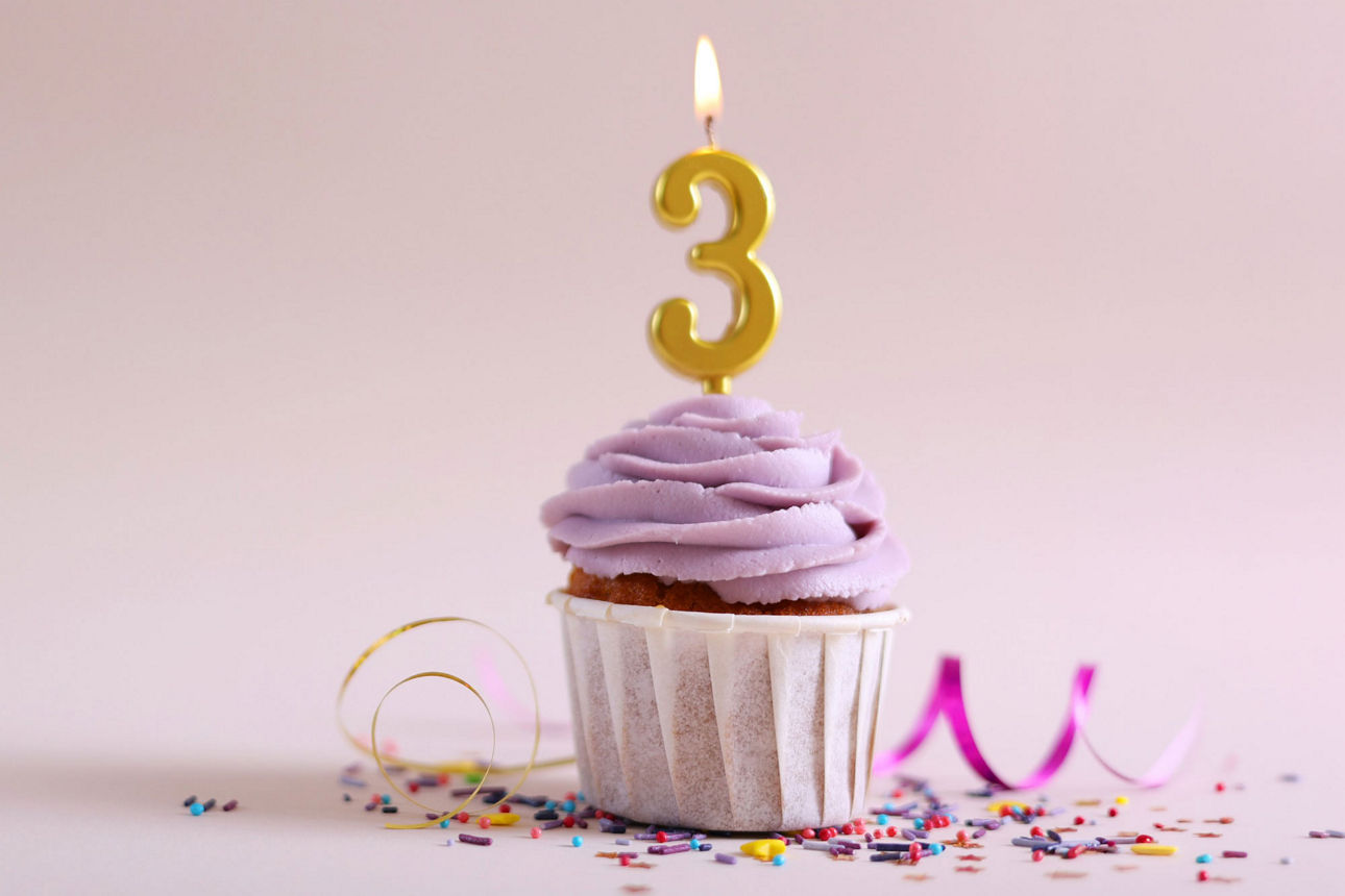 Cupcake mit Kerze „3“ und Hinweis auf Geburtstags-Festgeld ab 1.000 €.