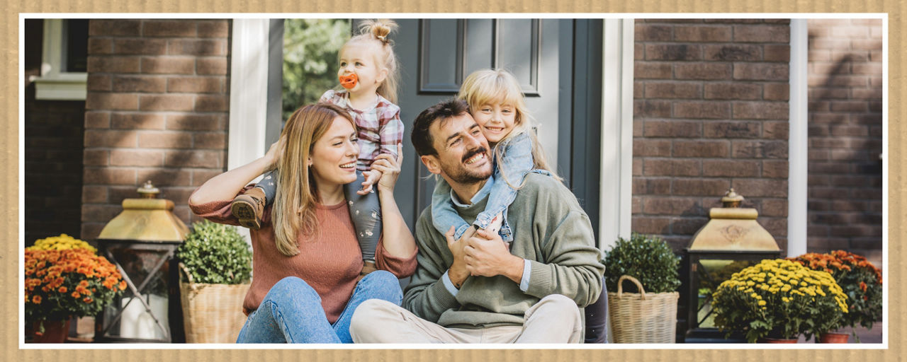 Familie sitzt vor dem Haus