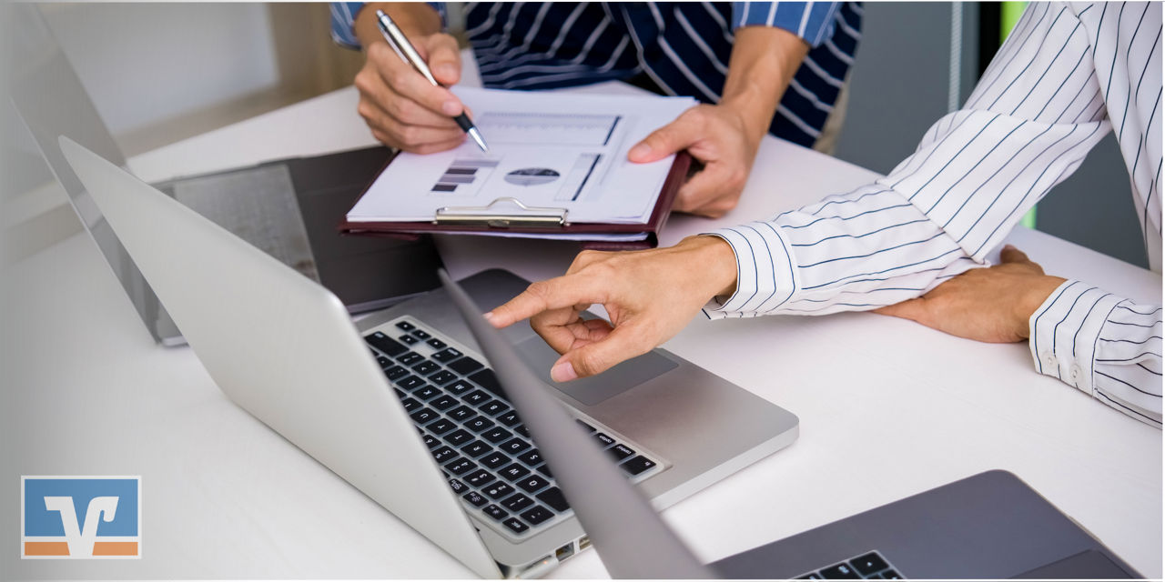 Zwei Personen arbeiten an Computern in einem modernen Büro.