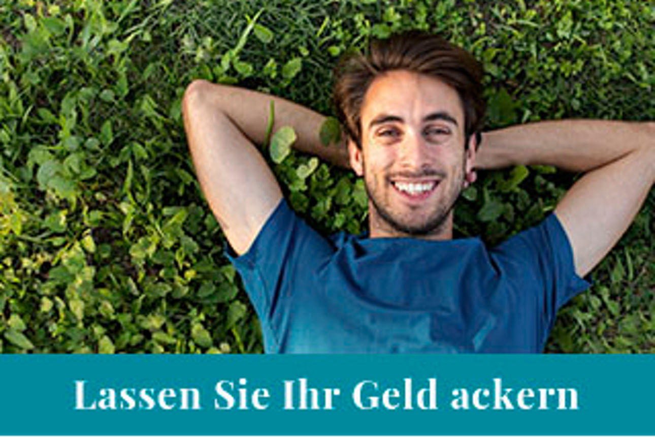 Mann liegt auf Rasen mit Händen hinterm Kopf