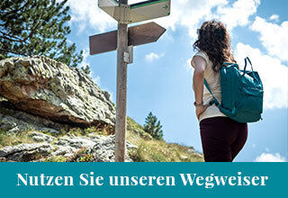 Frau beim Wandern vor Wegweiser 