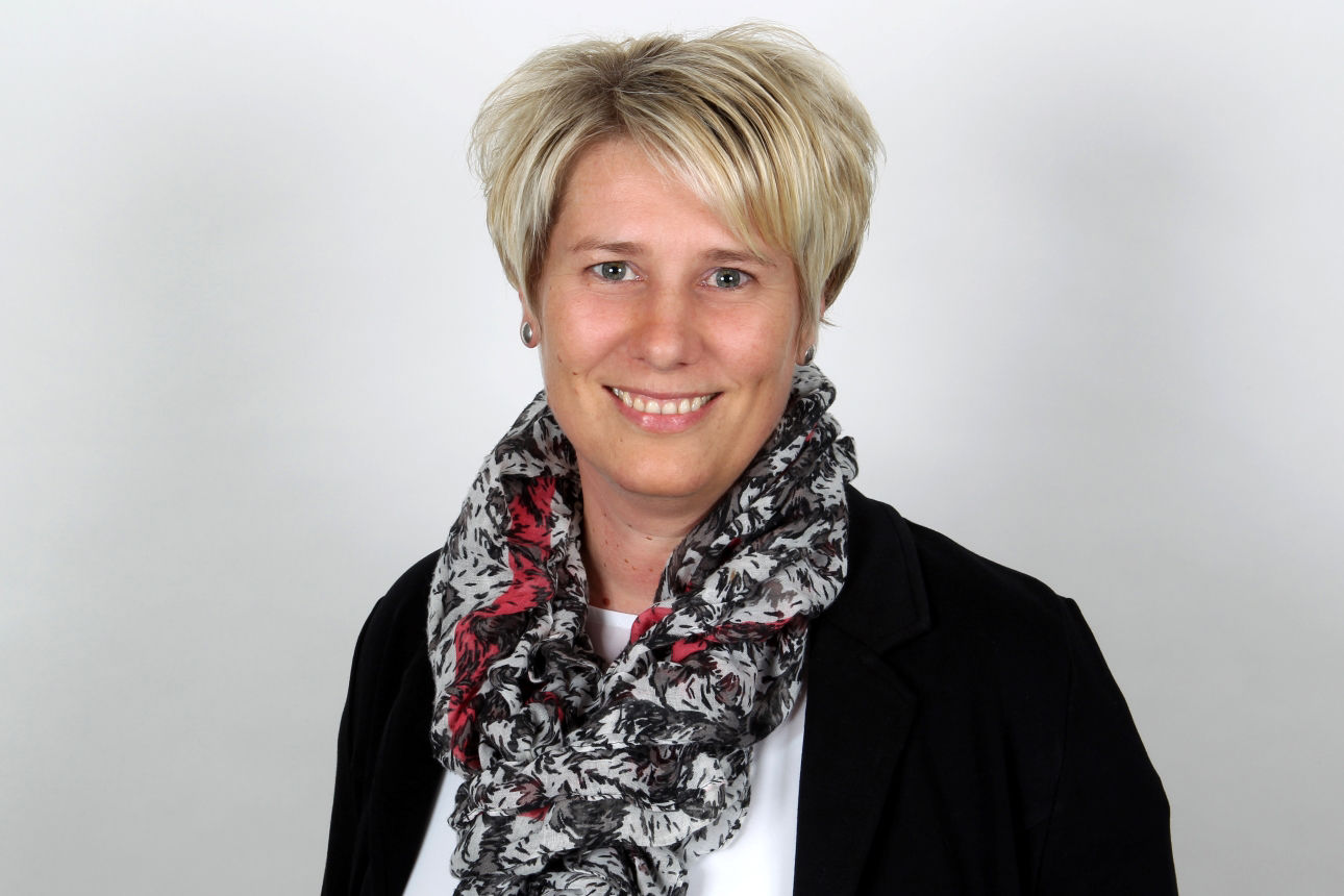 Eine lächelnde Frau schaut in die Kamera.