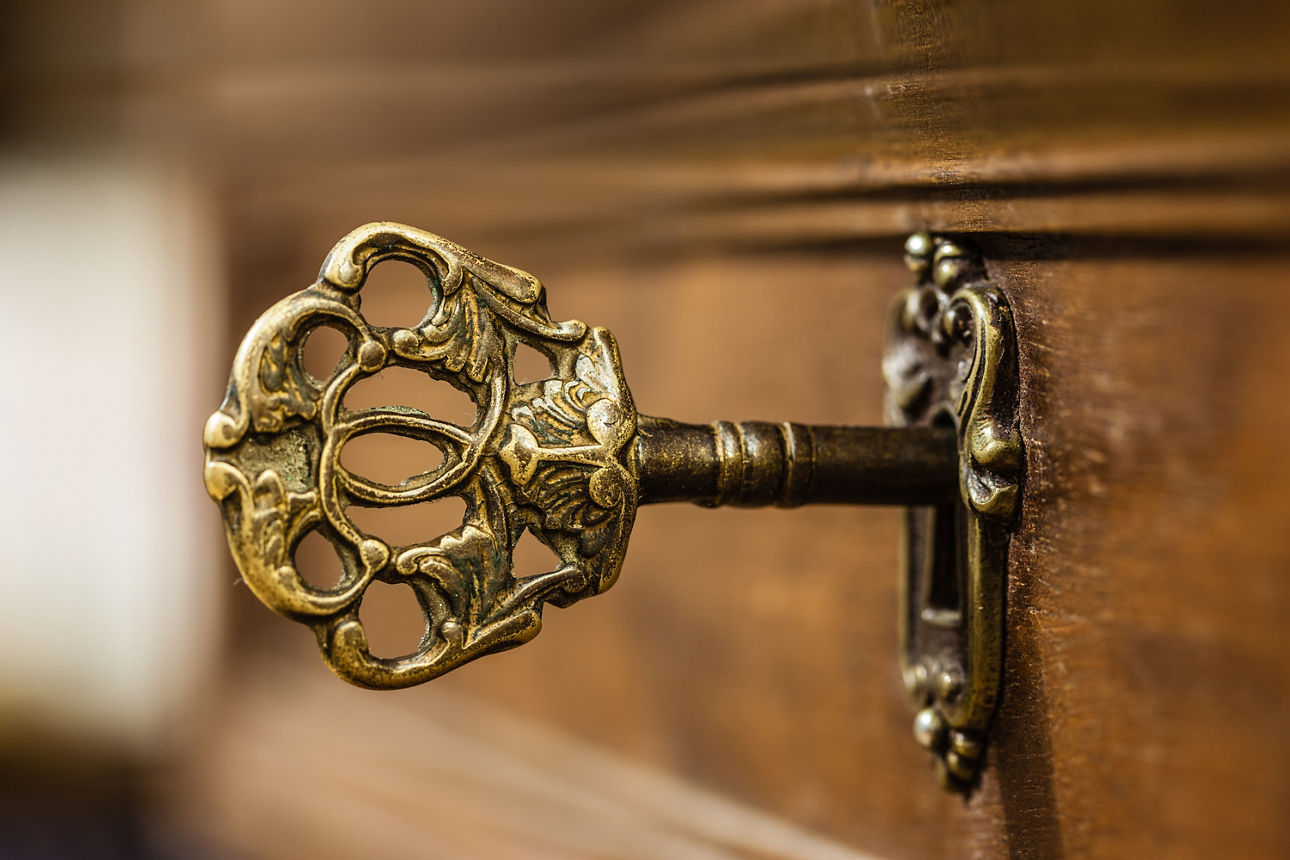 Ein verschnörkelter Schlüssel steckt in einem Schloss