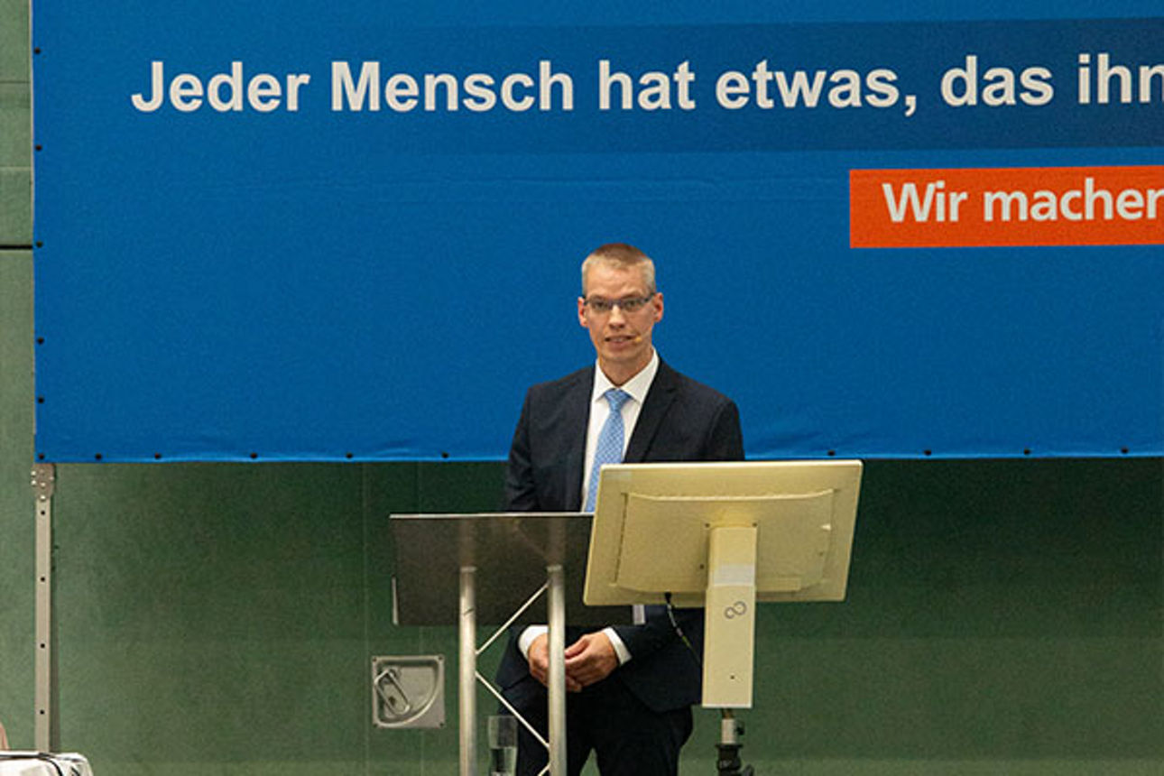 Männer in Firmenkleidung bei einer Konferenz präsentiert