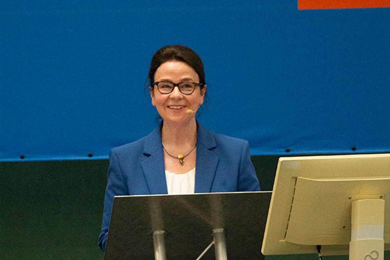 Frau in Firmenkleidung präsentiert auf einer Konferenz