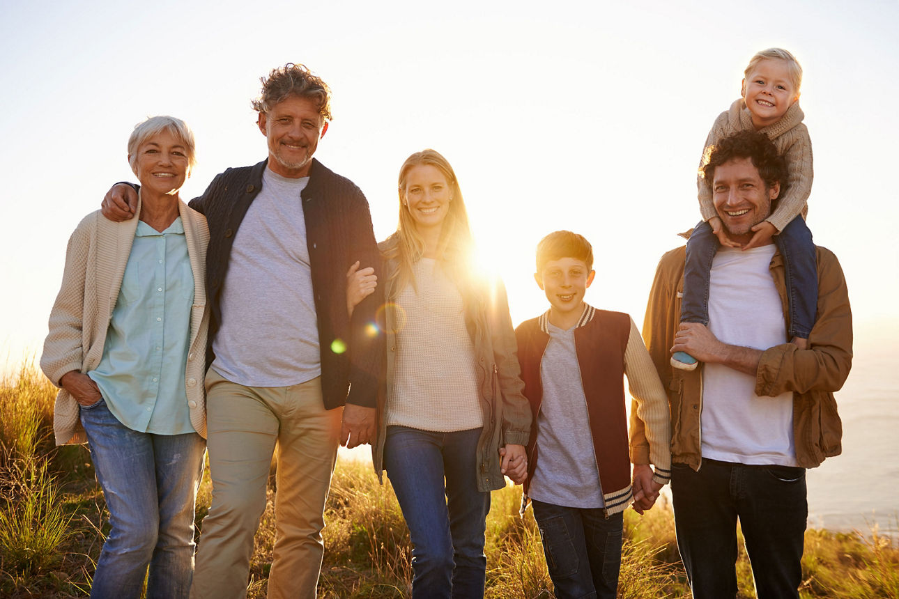 Eine Familiengeneration steht vor einem Sonnenuntergang