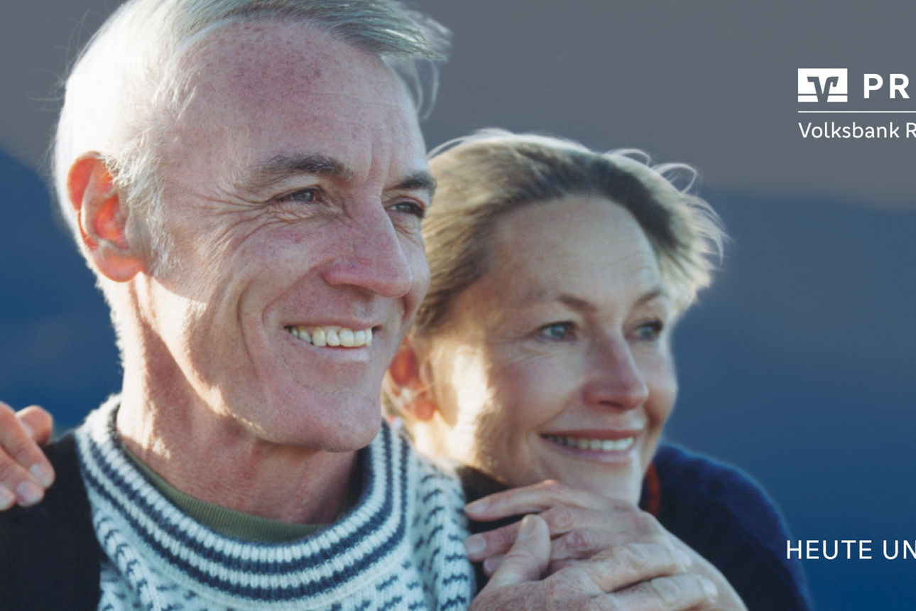 Älteres Ehepaar hält sich an der Hand und blickt zufrieden in die Ferne